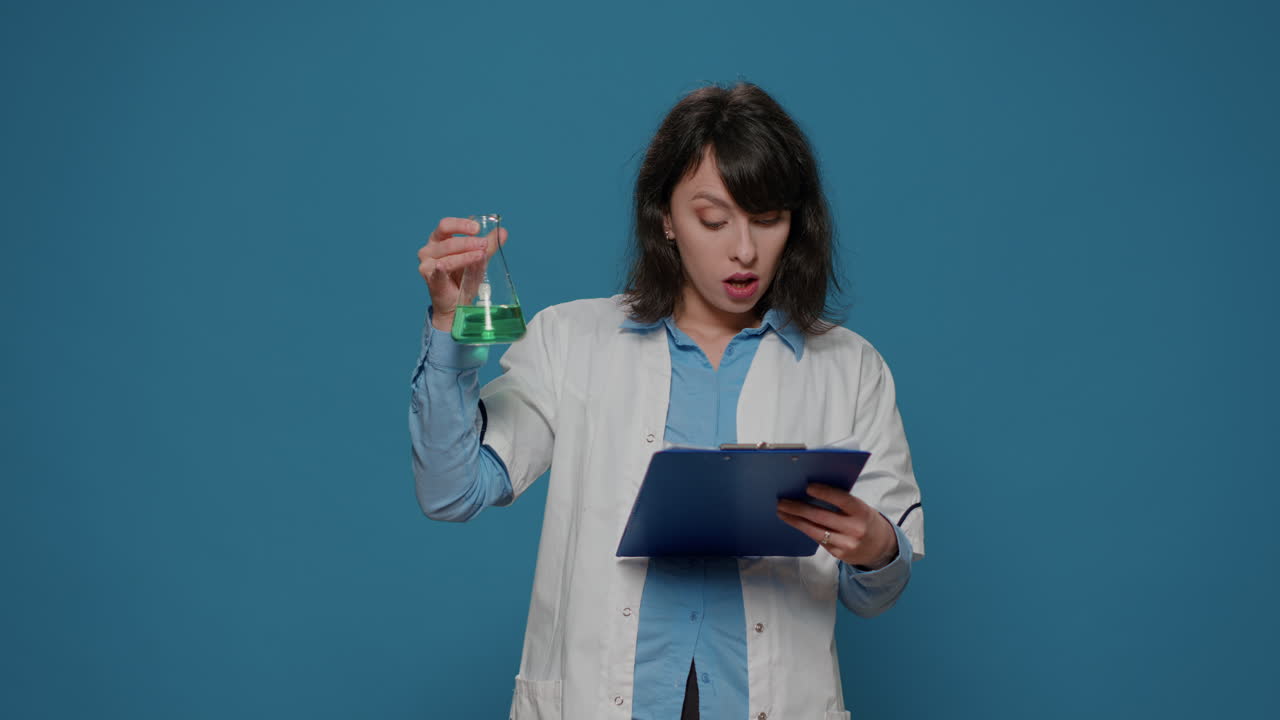 Female scientist analyzing liquid in beaker and chemistry files