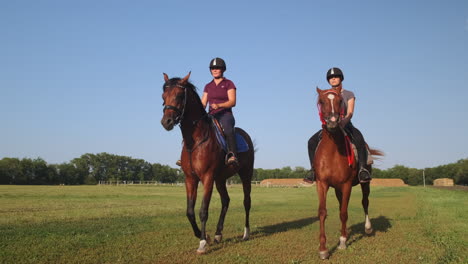 two women horseback riding