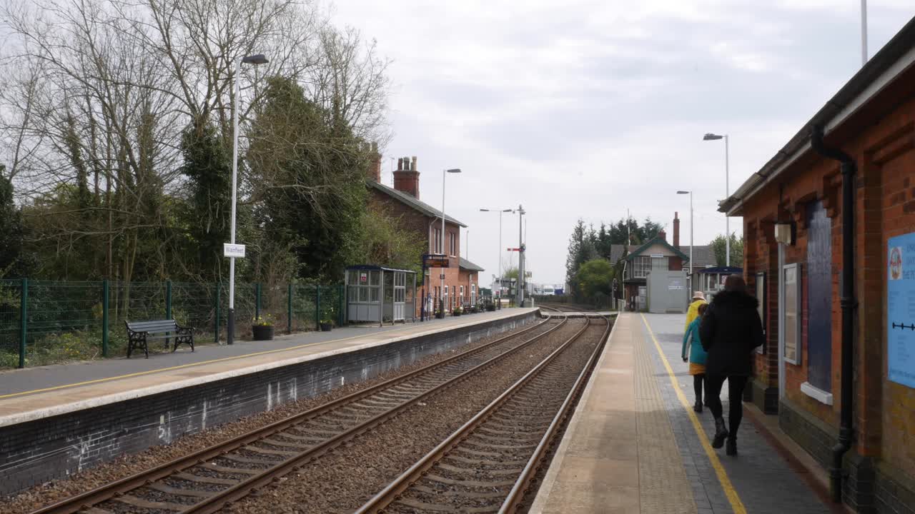 familia caminando por la plataforma de la estación de tren del pueblo