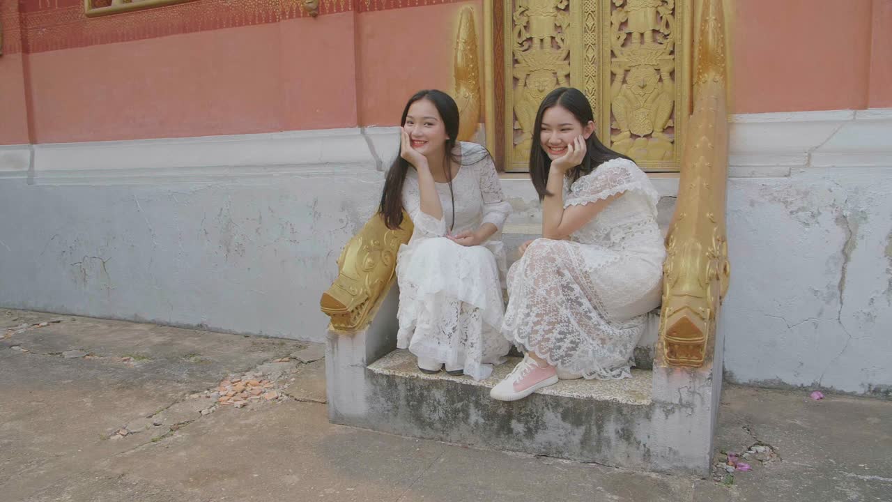 Two Asian Girls Pose On Stairs Of Temple, Slow Motion