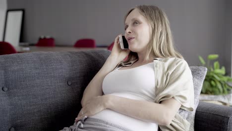 cheerful pregnant woman talking on smartphone