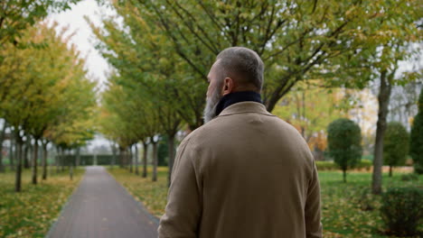 Close-up-view-portrait-of-adult-male-person-going-through-autumn-park.