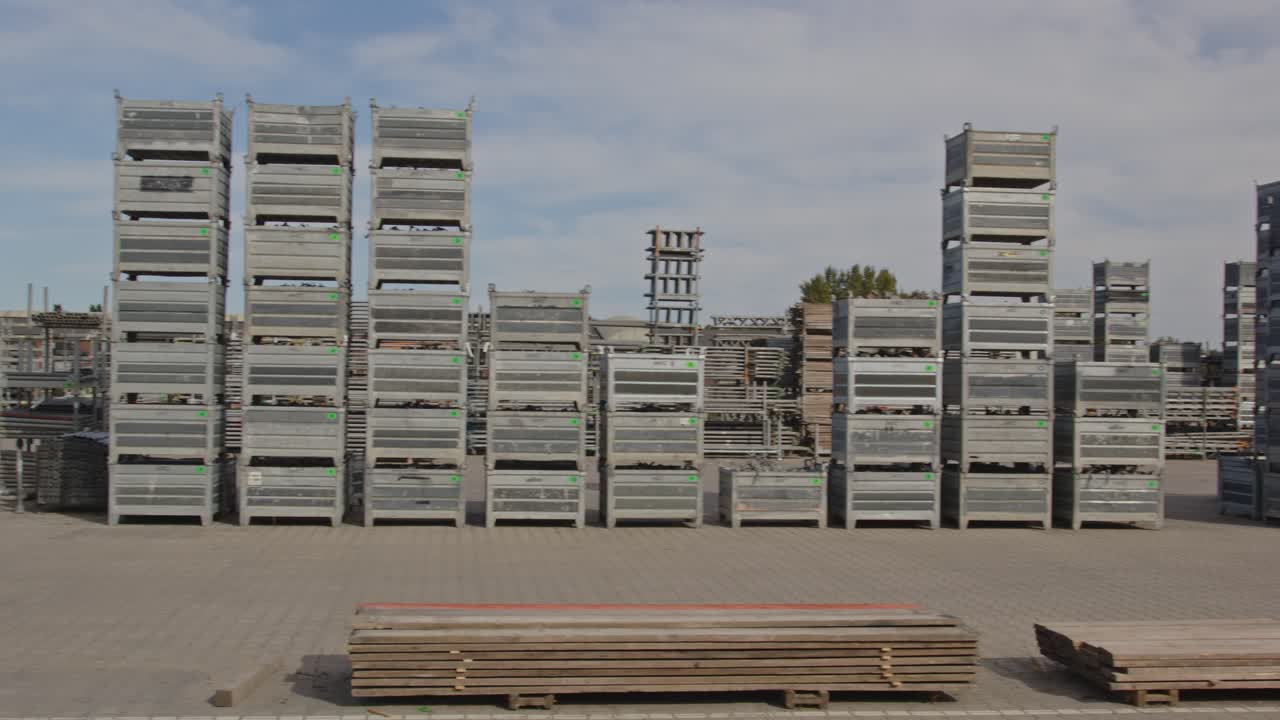 Pan of stacked construction materials on an industrial storage yard on a sunny day