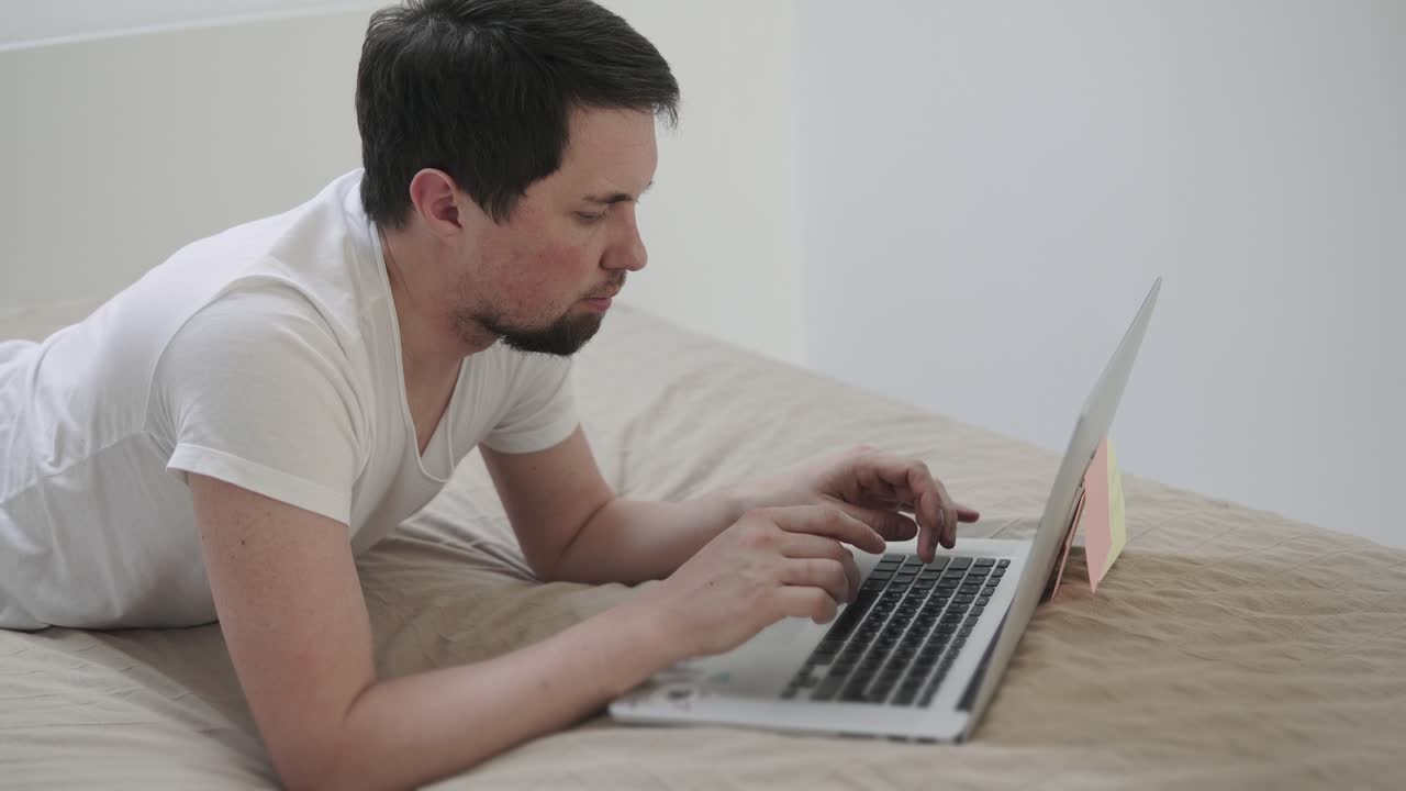 hombre trabajando en la computadora portátil en la cama