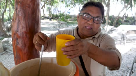 an indigenous mayan woman selling chocolate atole champurrado to customer