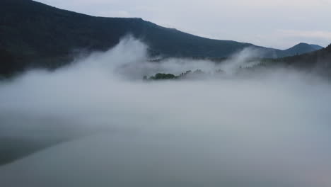 flight over a foggy river. the mist is hanging low over the landscape creating a dark mystical mood over the whole scene