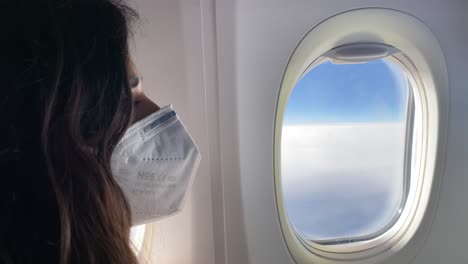 side face of a young woman wearing a face mask on a plane