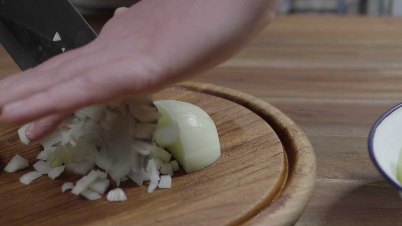 Hobby chef cuts onions into small dices for a delicious chimichurri
