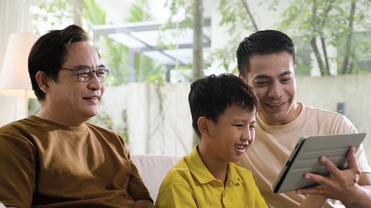 アジア人の男と男の子がリビングルームで