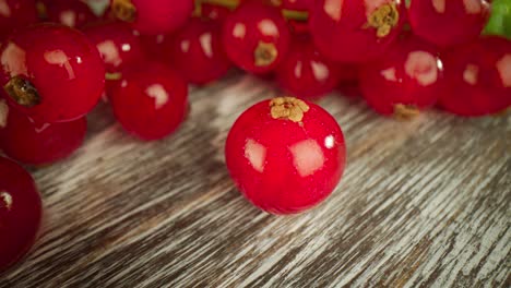 una macro muy cercana de una grosella roja en una mesa de madera.