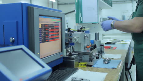 ingeniero monitoreando los datos de la pantalla mientras procesa las piezas. detalle de fijación del trabajador