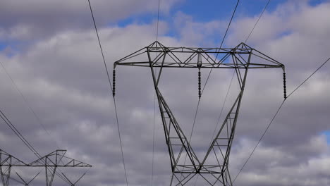 electrical tower with prominent insulators and time-lapsed clouds moving in sky