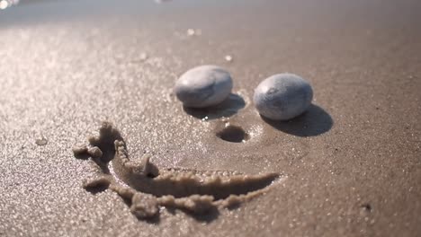 funny face on sand beach made from stones and sand