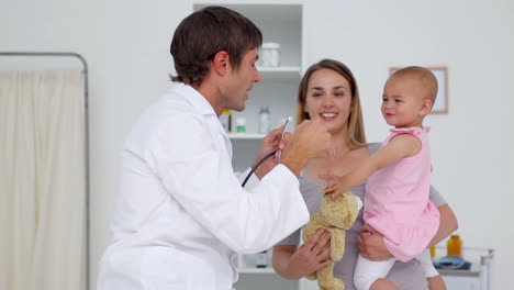 doctor using his stethoscope on a baby