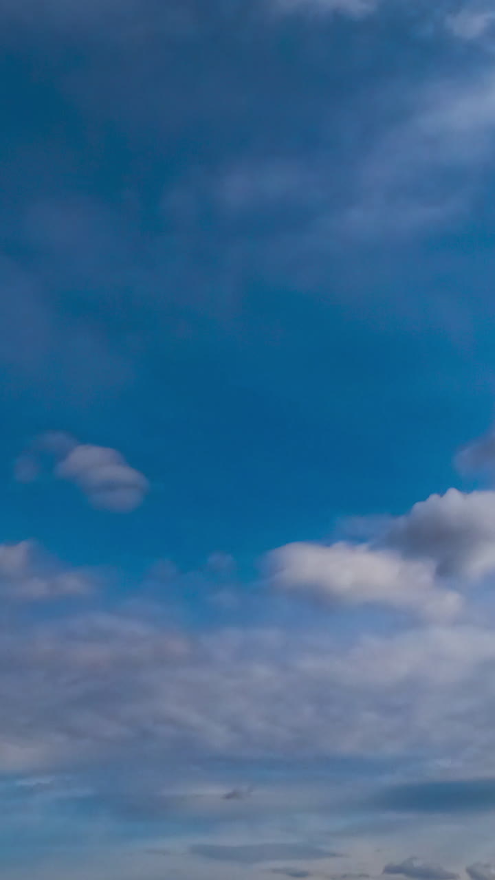 Light clouds transforming into heavy grey dramatic cloudscape. Low angle view. Timelapse. Vertical video
