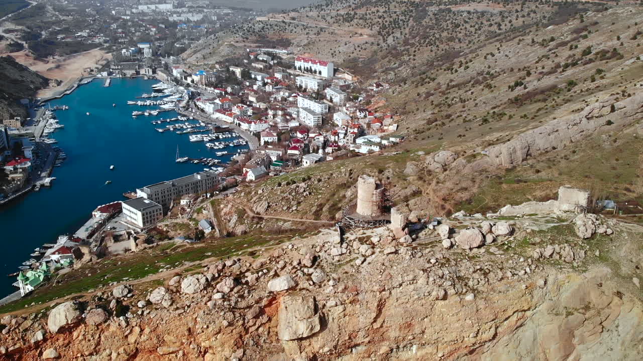 Aerial view of a coastal city with a bay and mountains