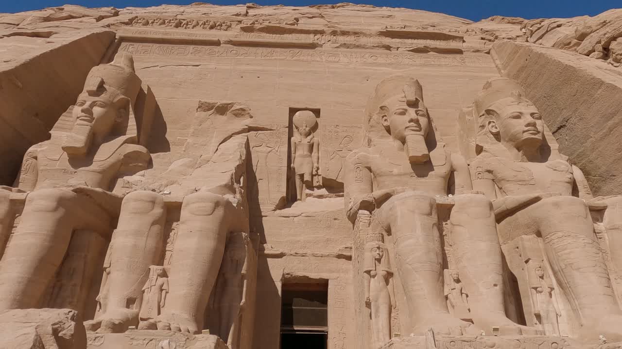entrada de abu simbel flanqueada por cuatro estatuas colosales que representan a ramsés ii sentado en un trono, egipto