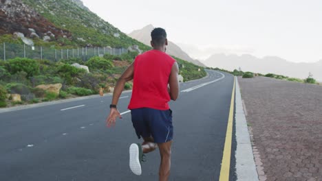 Hombre-Afroamericano-Haciendo-Ejercicio-Al-Aire-Libre-Corriendo-Por-Una-Carretera-Costera