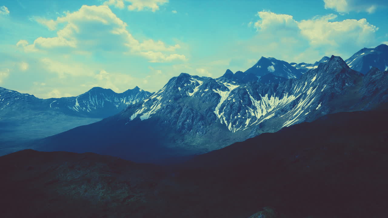 Aerial Over Valley With Snow Capped Mountains In Distance