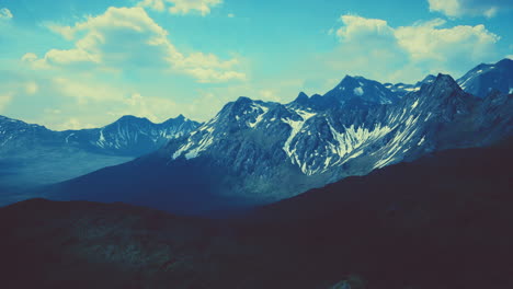 aerial over valley with snow capped mountains in distance