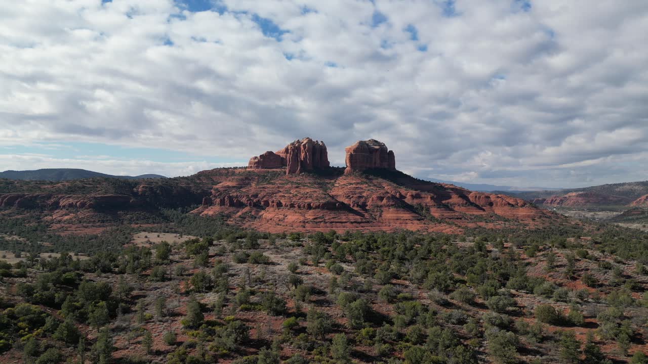 Aerial drone footage of Cathedral Rock in Sedona, Arizona, featuring dramatic red sandstone cliffs, desert landscape, and stunning views of this famous natural landmark under a clear blue sky