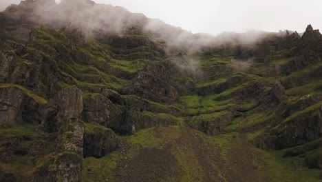 an-aerial-of-a-lush-mountain-with-puffins-flying