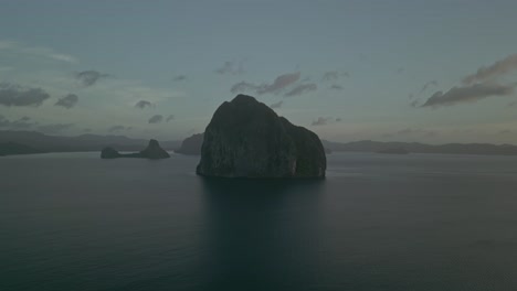 dramatic karst island in tropical bay at dusk