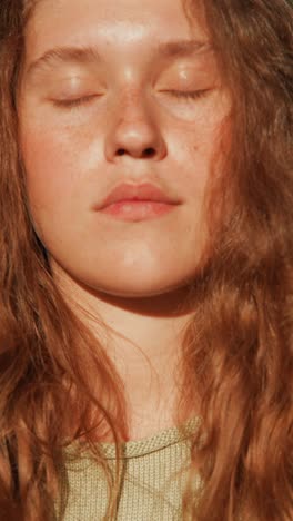 close-up portrait of a woman with curly hair and freckles