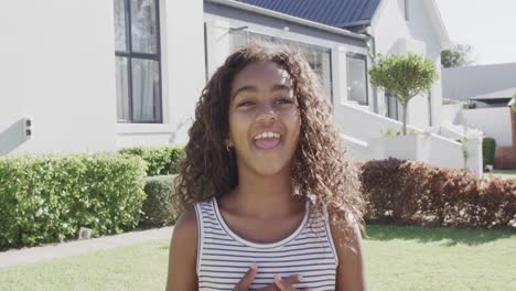 Retrato-De-Una-Feliz-Niña-Afroamericana-Saltando-Y-Sonriendo-En-El-Jardín,-Cámara-Lenta