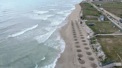 Olas-Espumosas-Rompiendo-En-La-Orilla-En-La-Playa-De-Vama-Veche,-Rumania---Toma-Aérea-De-Drones