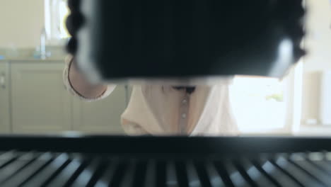 video of woman putting pressure cooker in the oven