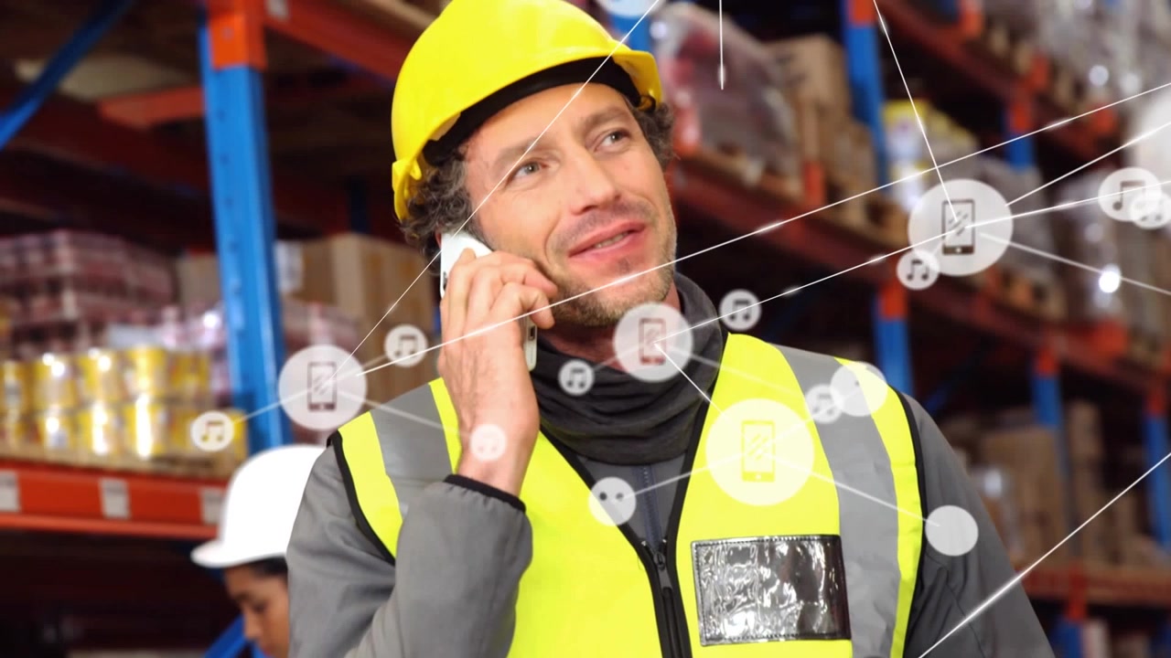 Animazione di una rete di icone digitali su un lavoratore caucasico che parla al telefono in un magazzino.