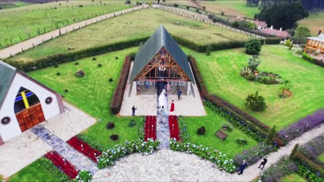 drone shot of bride entering in the a countryside church