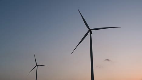 wind turbines silhouette against the blue-sky during sunset, clean alternative energy in thailand and mainland southeast asia