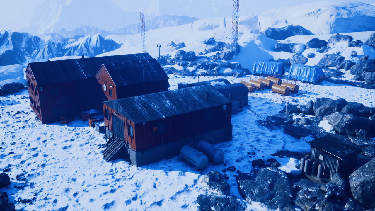 Winter landscape with red buildings near icy mountains and communication towers