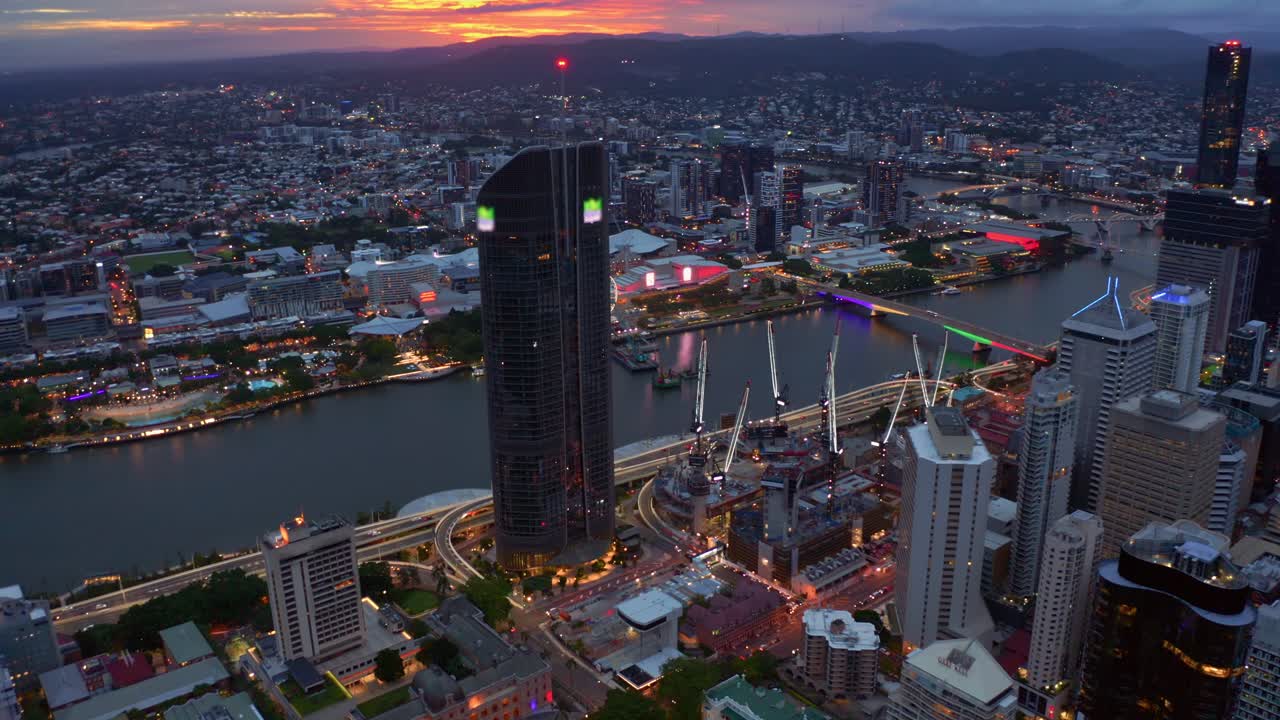 경치 좋은 빅토리아 다리와 퀸즐랜드의 휠 오브 브리즈번이 있는 브리즈번 강 옆의 노스 키와 사우스뱅크 파크랜드 너머의 일몰