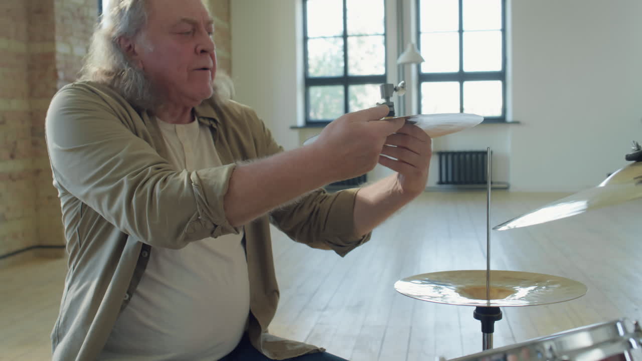Senior Drummer Changing Hi-Hat at Drum Kit