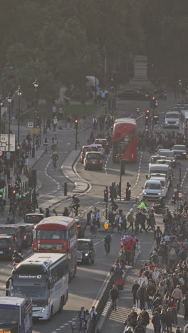 traffic and people crossing westminster bridge next to the houses of parliament, london, uk in vertical