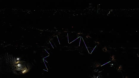 aerial: revelando la rueda de la fortuna con el horizonte de la ciudad de méxico por la noche