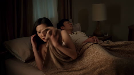 Woman experiences discomfort from a smell while her partner sleeps in bed