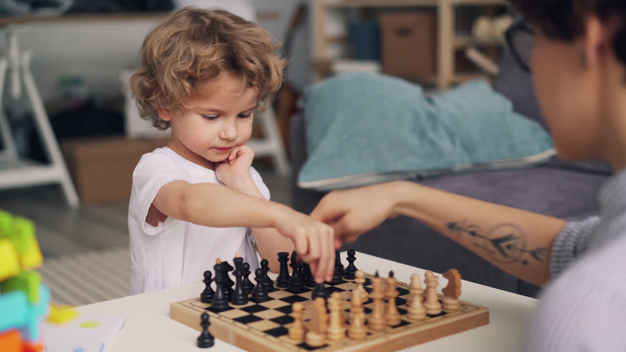 Child learning chess with parent