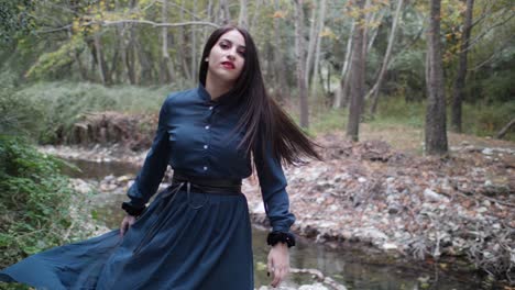 a beautiful gothic model dances and spins in slow motion in the woods