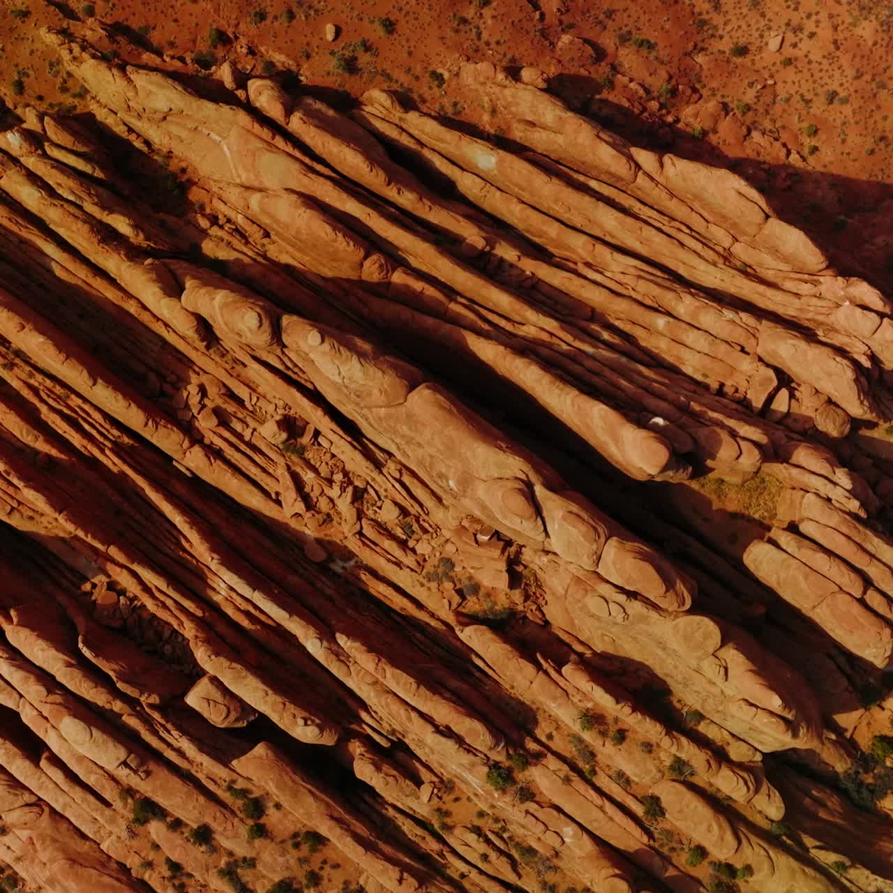 Fascinating rocks of Arches canyon cut like plates by the wind. Highway with a car moving by beside the mountains. Top view