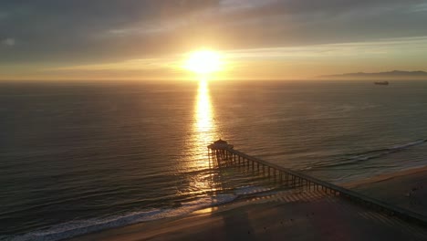 Puesta-De-Sol-Ardiente-Sobre-El-Muelle-De-La-Playa-De-Manhattan-En-California,-Ee.uu.---Toma-Aérea-De-Drones