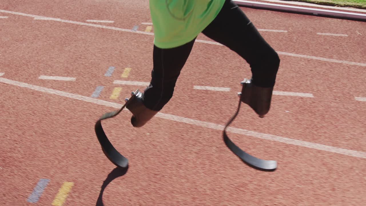 hombre de raza mixta discapacitado con piernas protésicas corriendo en la pista de carreras