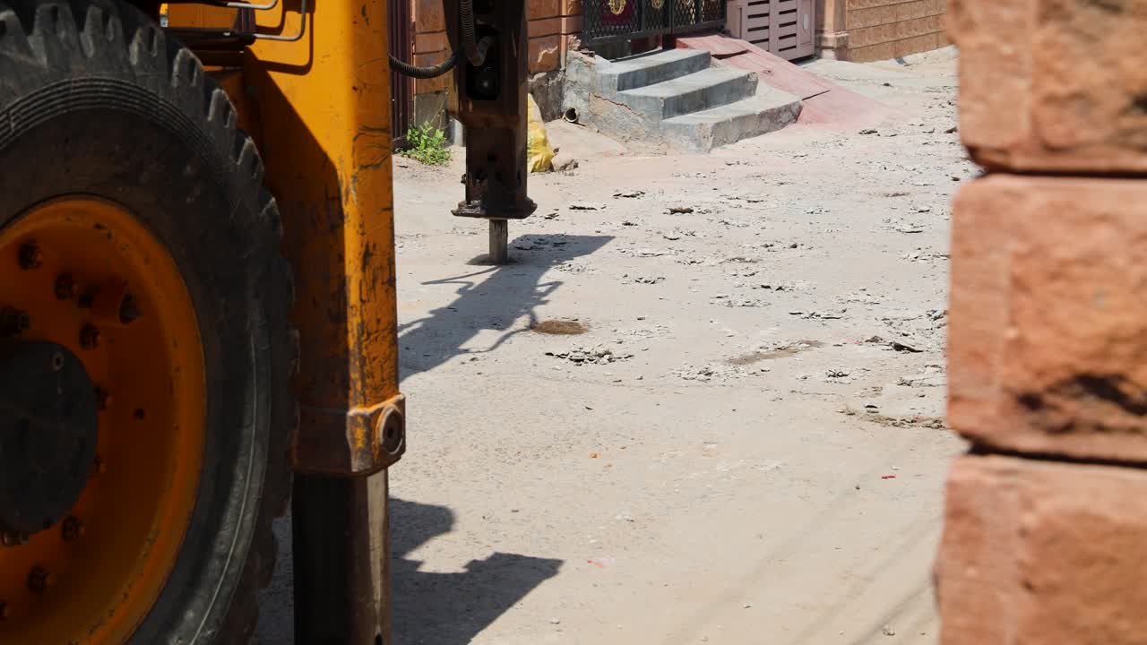 heavy machine breaking pavement for daytime construction