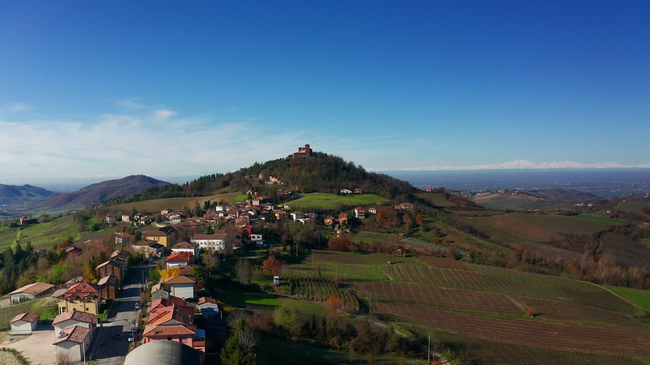 vista aérea de la ciudad local con vistas al castillo de montalto pavese en la cima de una colina en el fondo en lombardía, italia