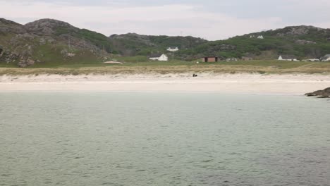 slow panning shot of achmelvich bay with suliven towering in the background
