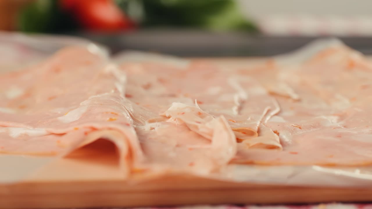 Ham italian mordatella, man Slices Of Traditional Italian antipasti mortadella sausage on a wooden cutting board, close up macro of chicken or turkey jamon, fat breakfast dish.