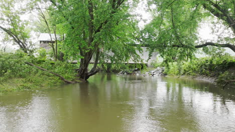 Still-Water-and-Green-Trees-at-Gates-Farm-Covered-Bridge-in-Rainy-Cambridge,-VT